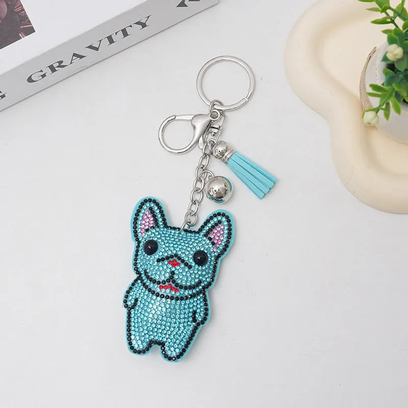 Close-up of a caramel-coloured cartoon dog rhinestone keychain pendant on a keyring.