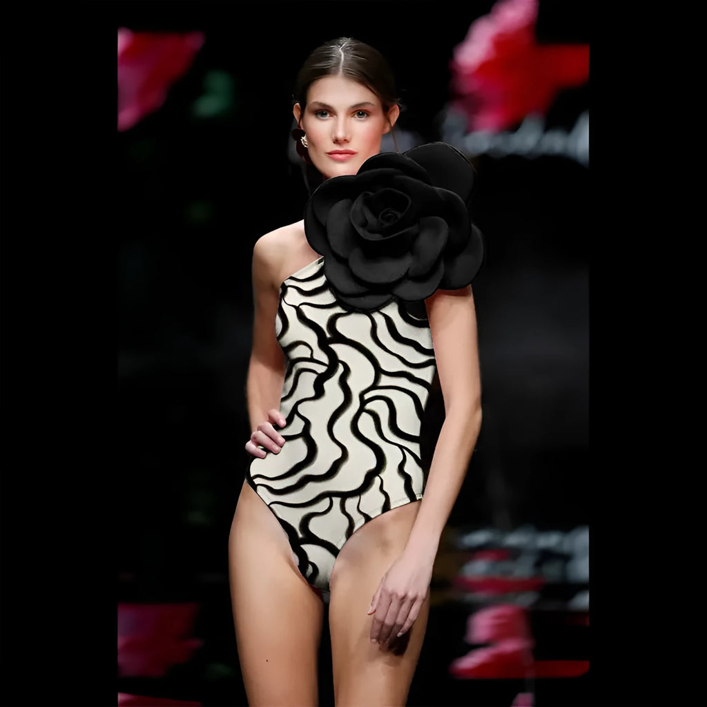 Women's black floral one-piece swimsuit with three-dimensional pattern on polyester fabric.