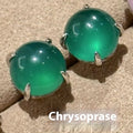 Round chalcedony stud earrings with four claw copper settings in green, white, or pink.
