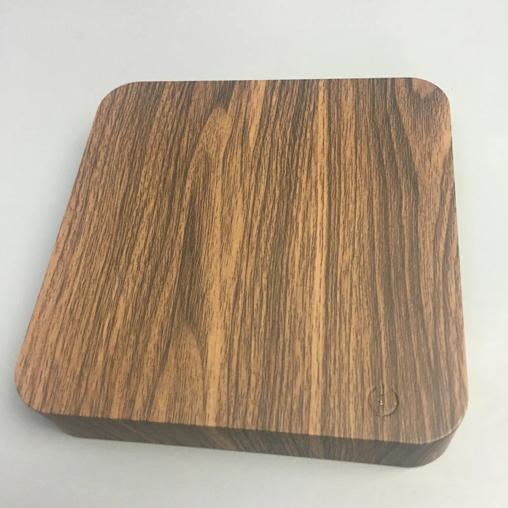 Square walnut coloured base with a levitating, glowing galaxy-patterned moon lamp above it