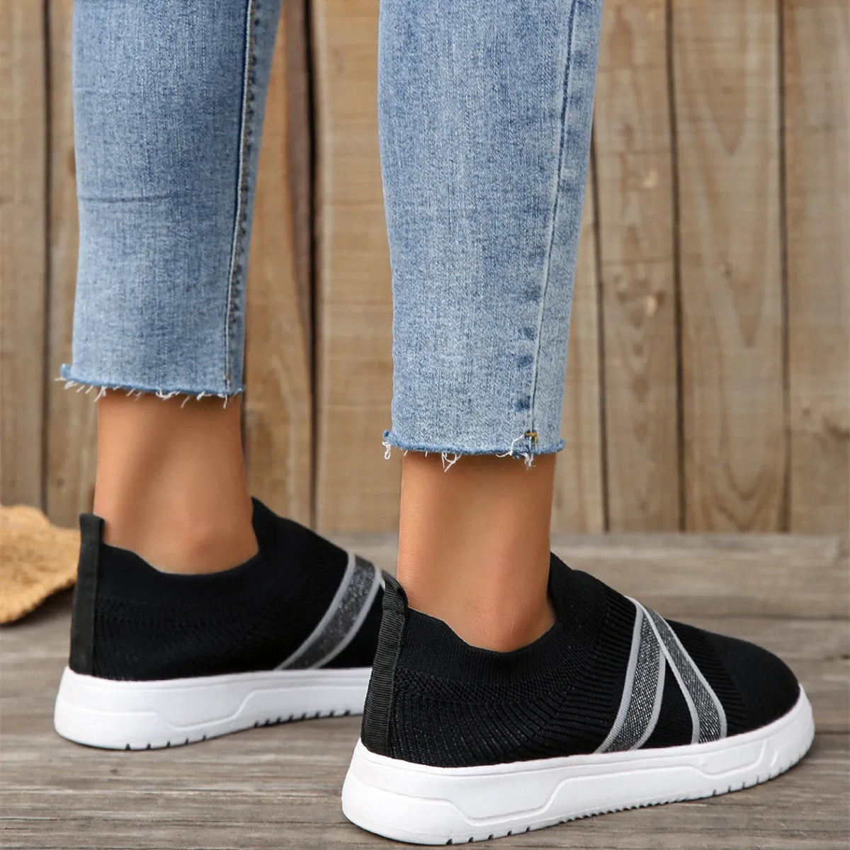 Women's black casual shoes with fabric mesh upper and flat rubber sole on neutral background