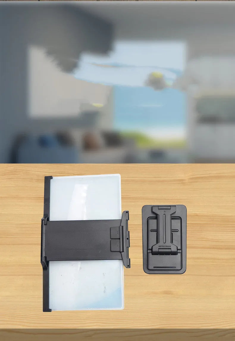 Black folding mobile phone screen amplifier with detachable holder, shown magnifying a smartphone display.