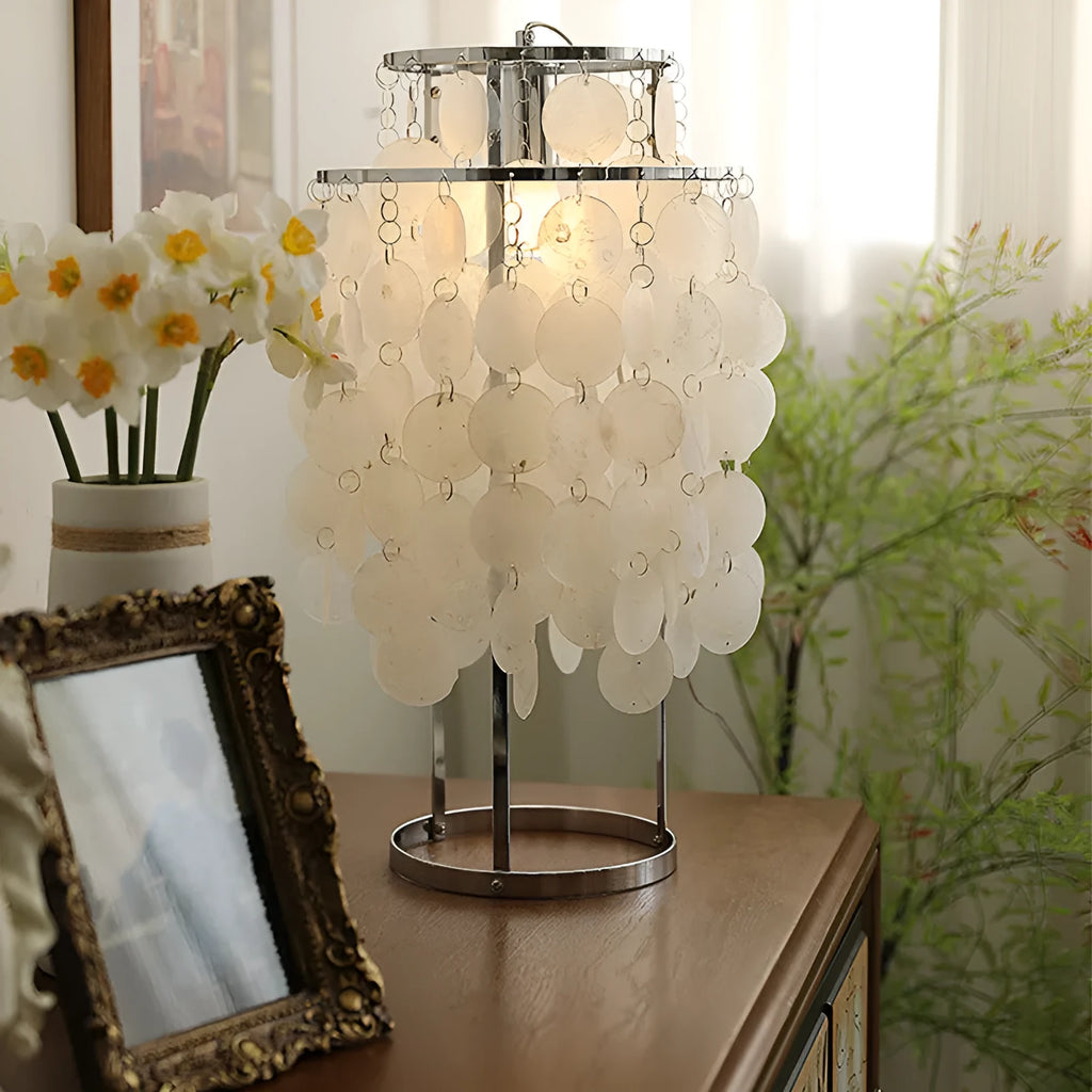 Modern single-head Shell bedside table lamp in chrome finish on a wooden table.