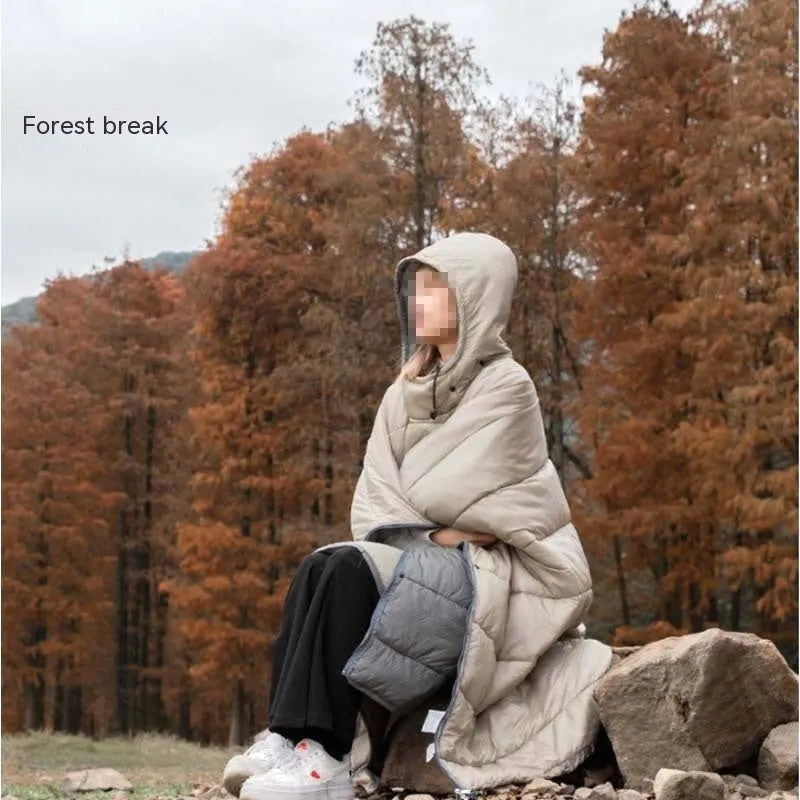 Adult wearing a grey outdoor cloak sleeping bag, showing its full 200x140cm size and hood.