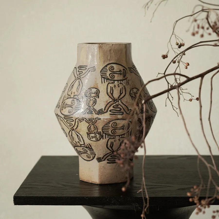 Hand-painted ceramic cylindrical vase with carved religious patterns in tribal totem flower design