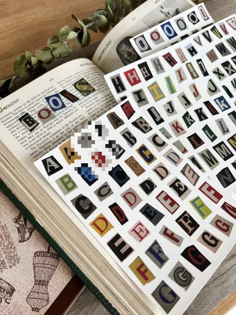 Set of printed cute-style stickers showing English letters, numbers, and weekday words on a sheet.