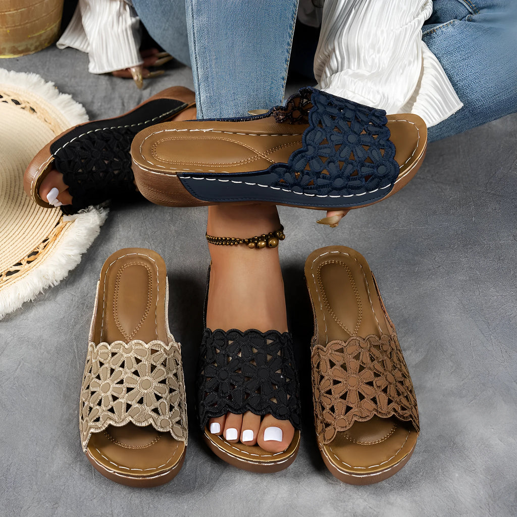 Women's black wedge beach slippers with floral cutouts and an open fish mouth toe design.