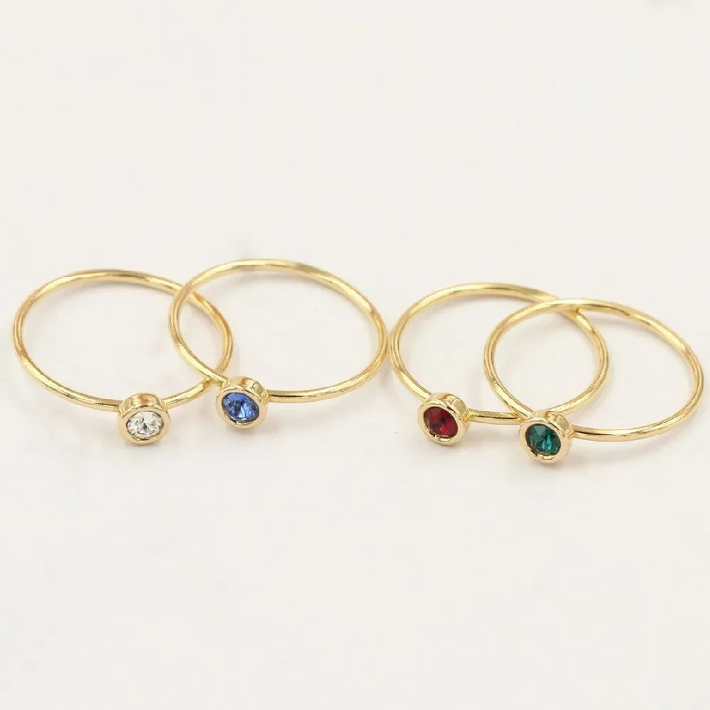 Copper knuckle ring with gold gild and coloured GF zircon stones on a finger.