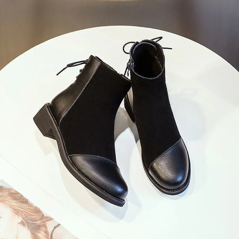 Black women's knee-high Martin boots with side zip and round toe on a rubber sole.