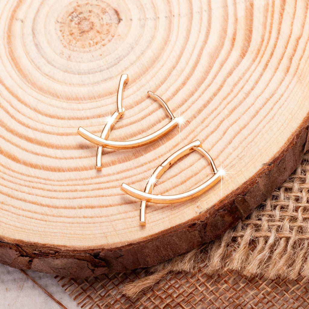 Rose gold cross shaped drop earrings with copper construction and light luxury finish