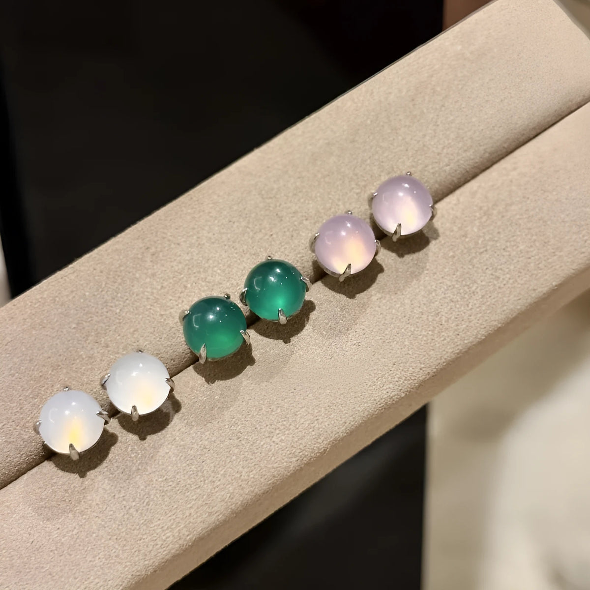 Round chalcedony stud earrings with four claw copper settings in green, white, or pink.