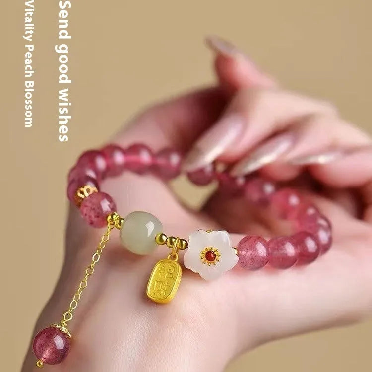 Handmade women's strawberry quartz crystal bracelet with pearl, moon, and XINGX designs