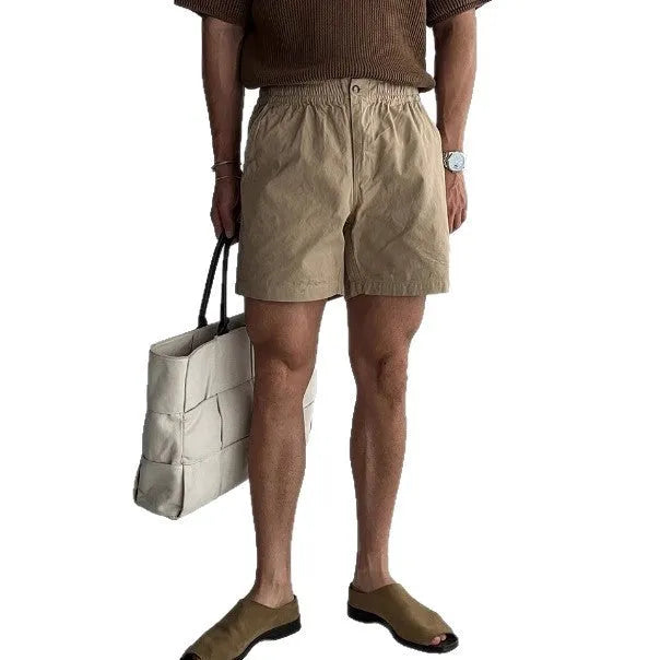 Cotton loose fit sports shorts in black, shown on a hanger.