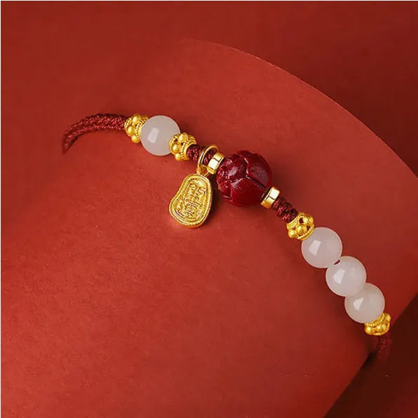 Women's adjustable silver bracelet with Hetian jade and red cinnabar rope decoration on a light background
