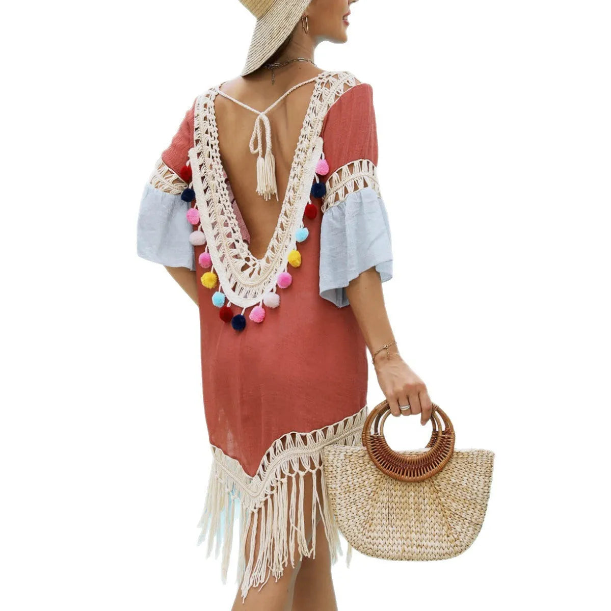 Orange floral print beach overskirt with hand crochet detail and tassels, laid flat.