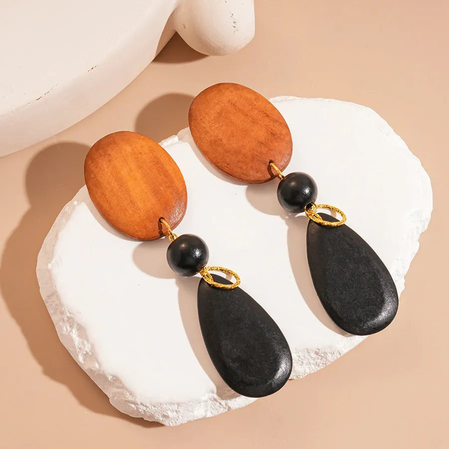 Hand-crafted wooden oval earrings in silver needle and brown-black retro style.
