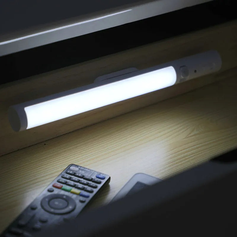 Long white LED human body induction cabinet light with magnetic strip on back for wall or wardrobe mounting.