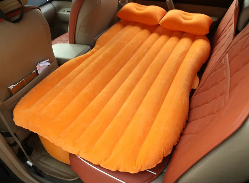 Universal inflatable car bed with flocked surface and pillows laid out in a car boot.