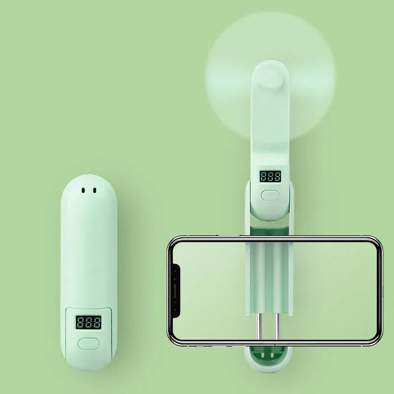 Green folding mini USB fan with plastic leaves, shown open and closed, on a white background.