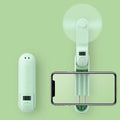 Green folding mini USB fan with plastic leaves, shown open and closed, on a white background.