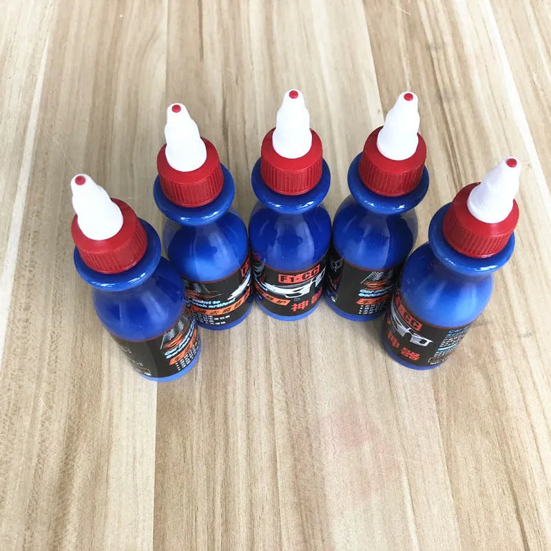 Small blue wiping tool and bottle of automobile scratch repair agent for minor vehicle surface imperfections