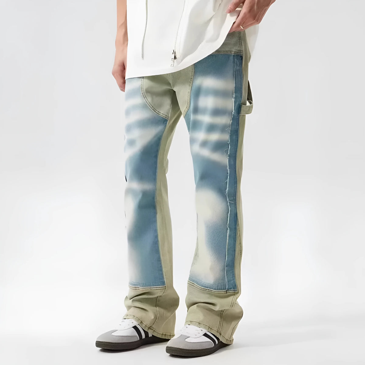 Yellow and blue patchwork jeans with a distressed splash-ink design on a mid-waist fit.