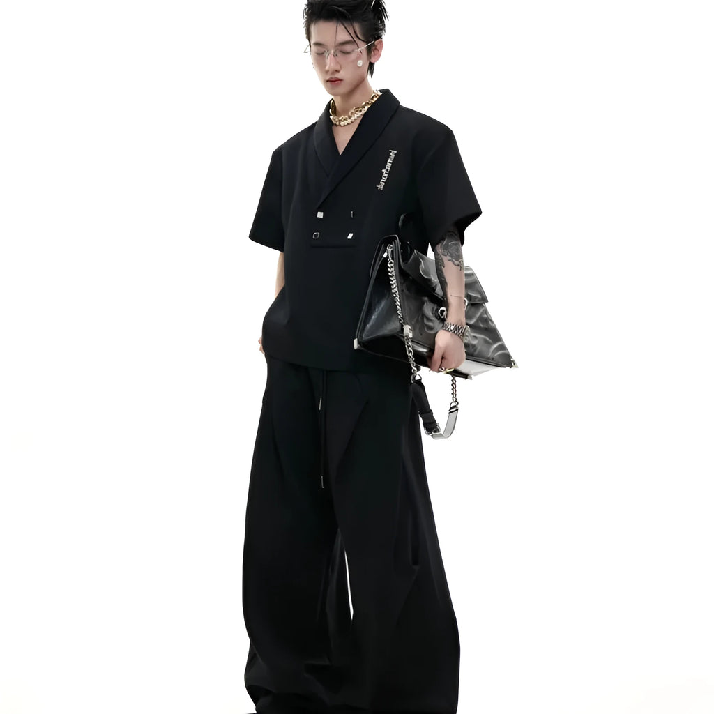 Men's dark grey cotton sports suit with V-neck jacket featuring padded shoulders and metal details, worn with matching shorts