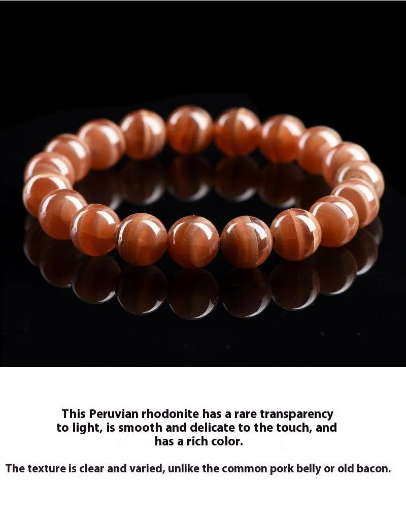 Natural Old Mine Rhodochrosite round bead bracelet with Ruyi design elements on a wrist.