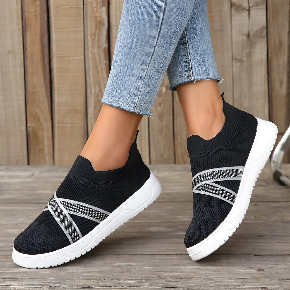 Women's black casual shoes with fabric mesh upper and flat rubber sole on neutral background