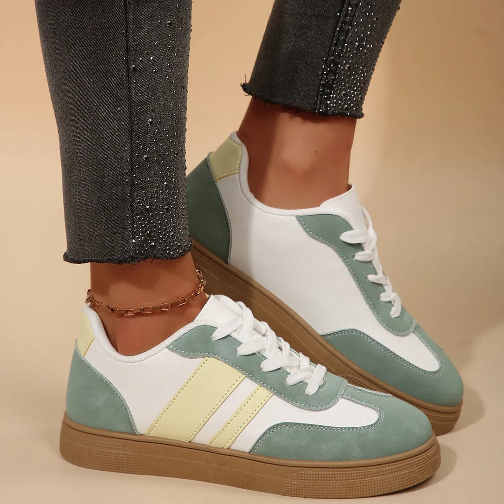 Green women's retro sports pumps with white cross straps and a round toe.