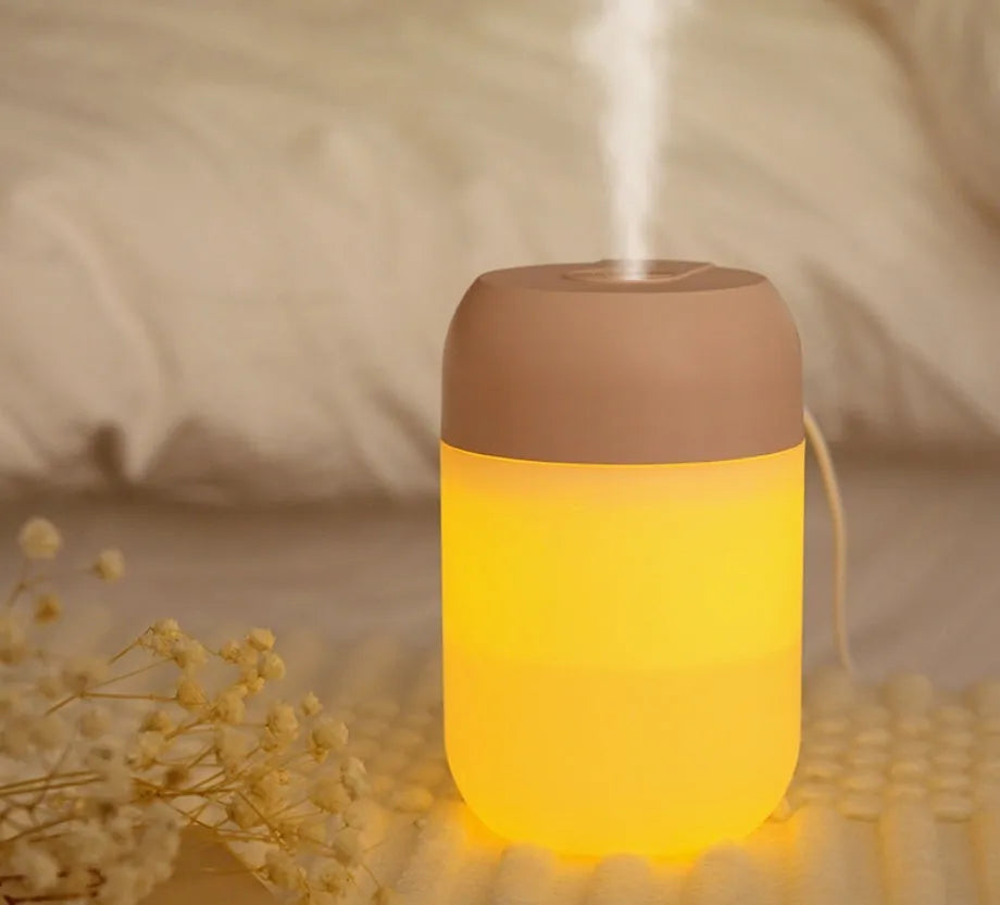 White cylindrical USB mini humidifier with charging cable on flat surface