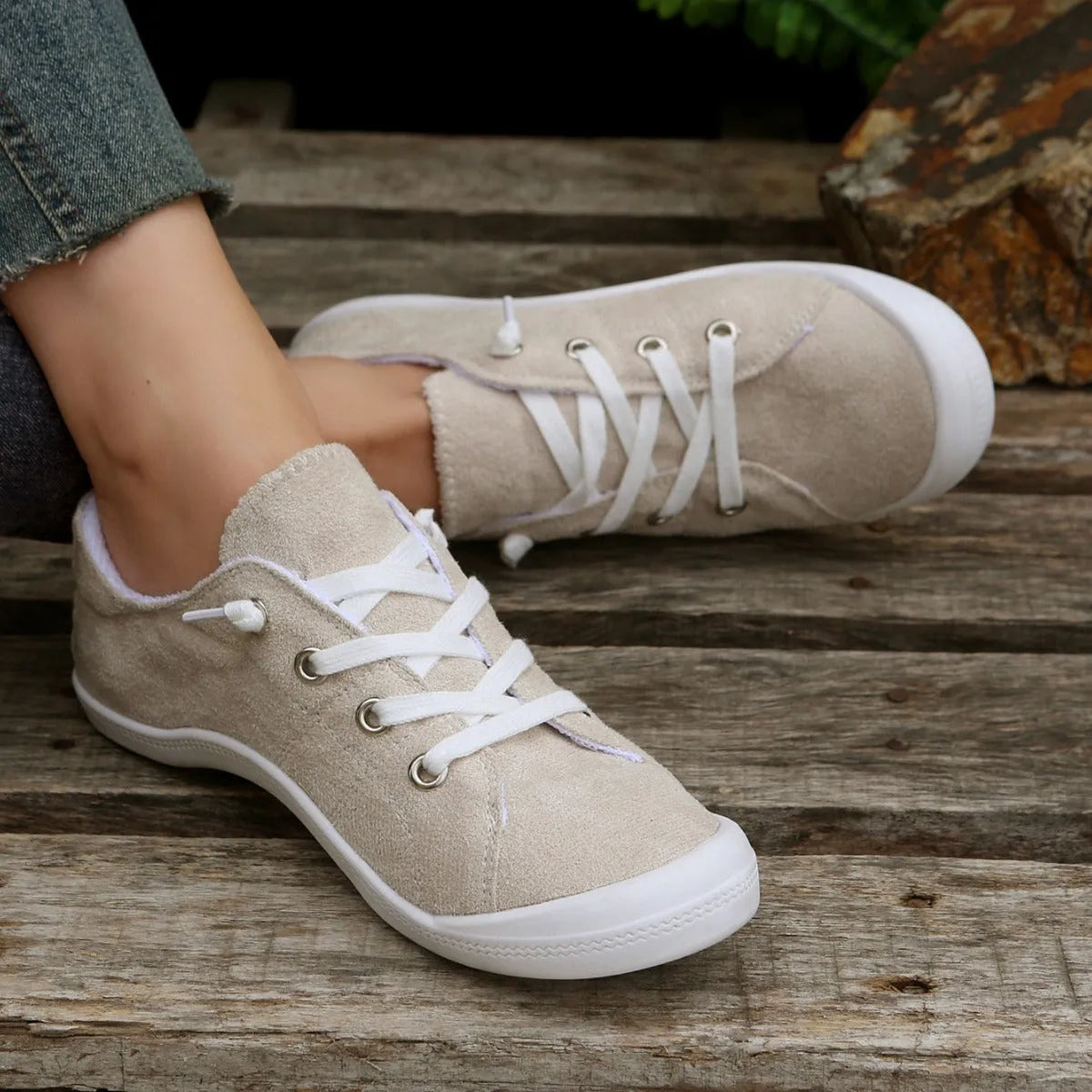 Women's creamy-white low-top fabric sneaker with rubber sole shown from side view