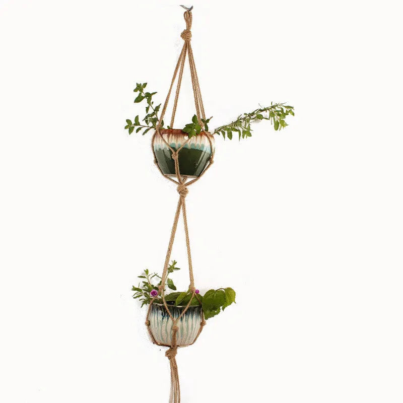 Woven cotton rope plant hanger in wall hanging configuration with green plants