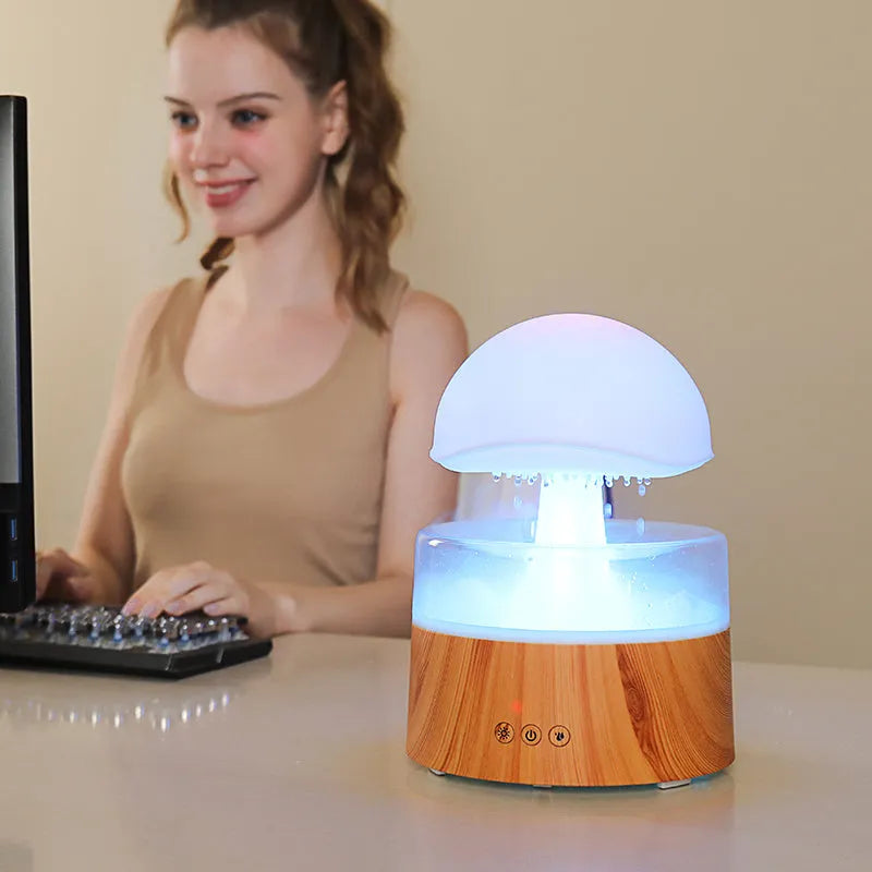 White cloud-shaped humidifier and aroma diffuser with simulated raindrops and coloured night light