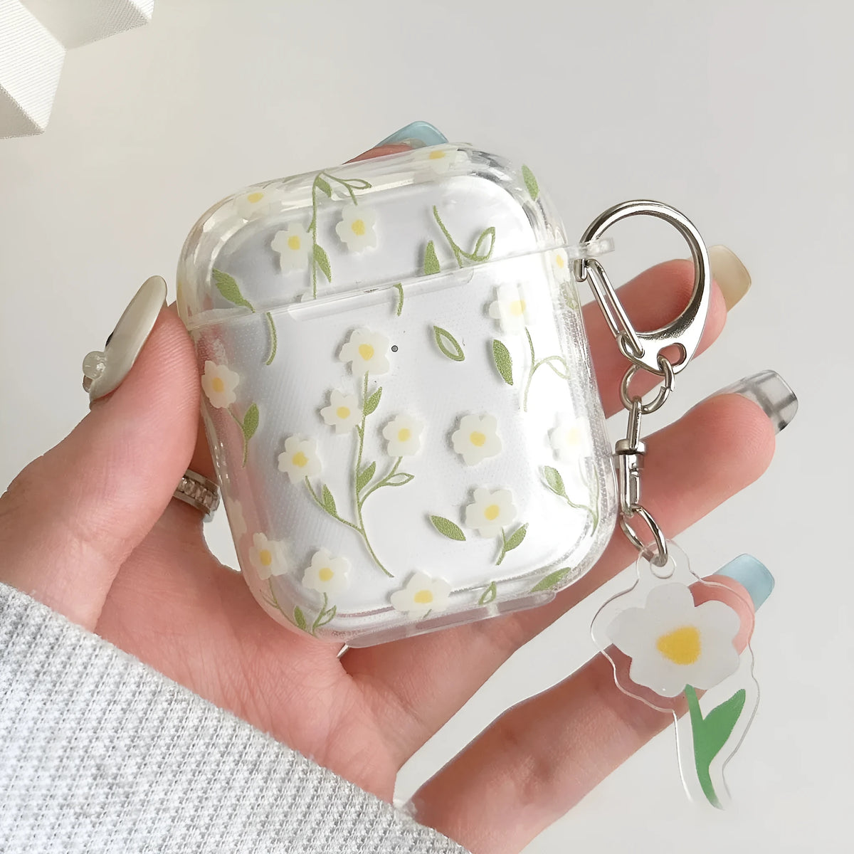 White floral decorative pattern on a high transparency TPU protective case for Apple AirPods.