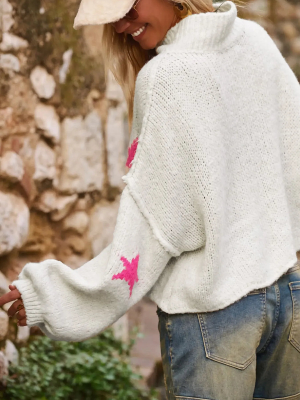 White loose women's turtleneck pullover with a black five-pointed star pattern on the front.
