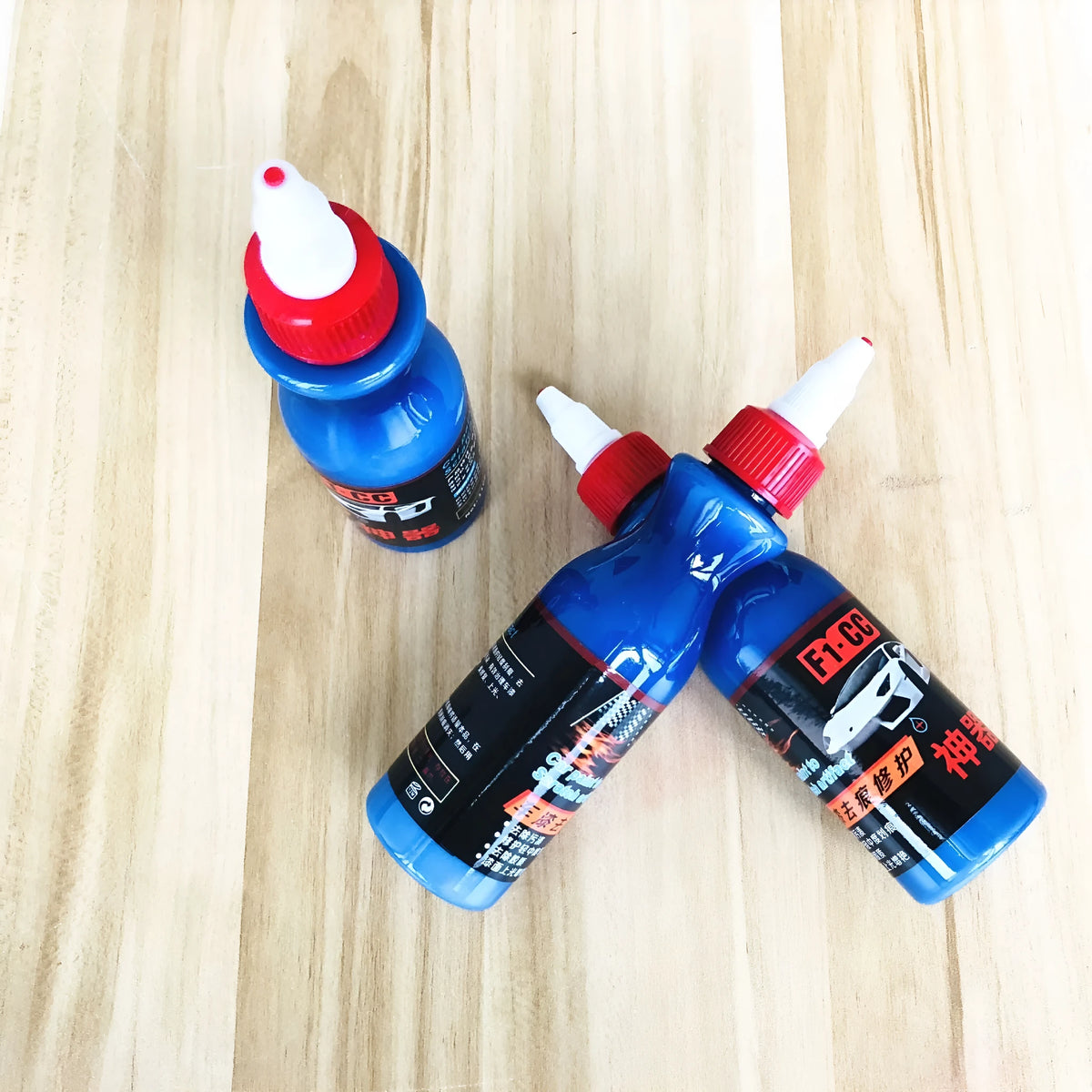 Small blue wiping tool and bottle of automobile scratch repair agent for minor vehicle surface imperfections