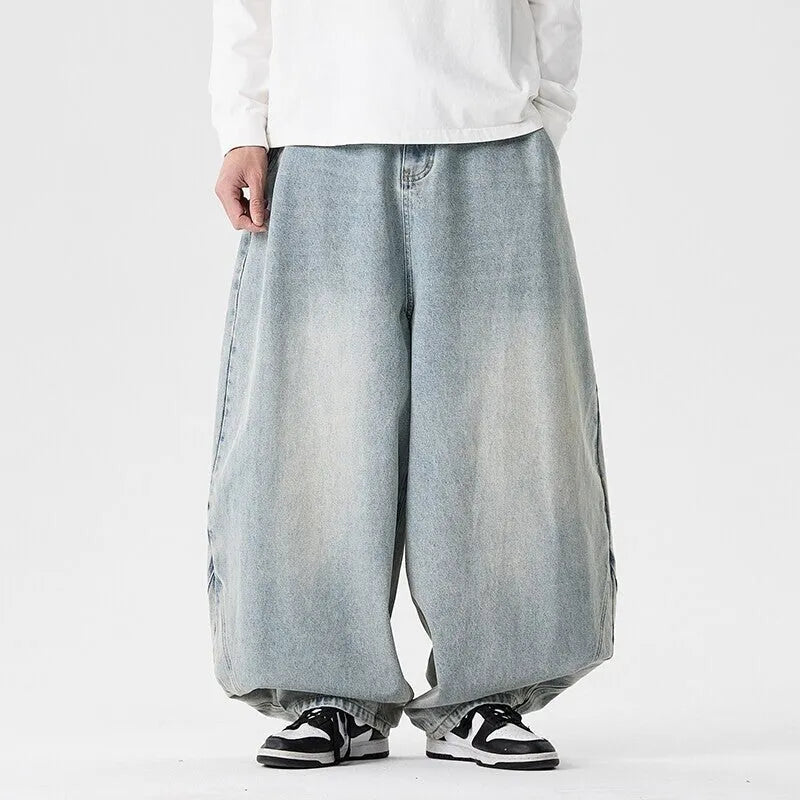 Men's loose fit light blue denim jeans with a straight leg and low waist, laid flat.