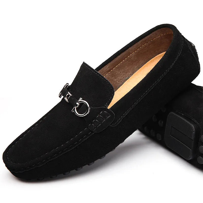 Men's black slip-on leather shoes with a square toe and matte finish on a plain background.