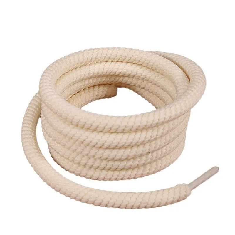 Round white woven shoelace with 10mm diameter next to a beige and black lace on a grey background.