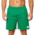 Man wearing solid green quick-drying nylon shorts with a straight leg opening on a beach.