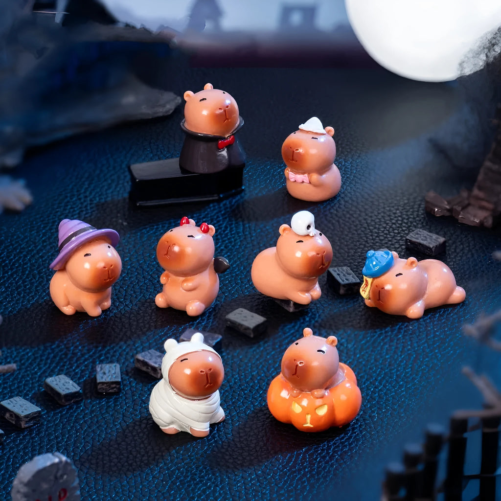 Eight small resin and plastic capybara figurines with different Halloween-themed designs.