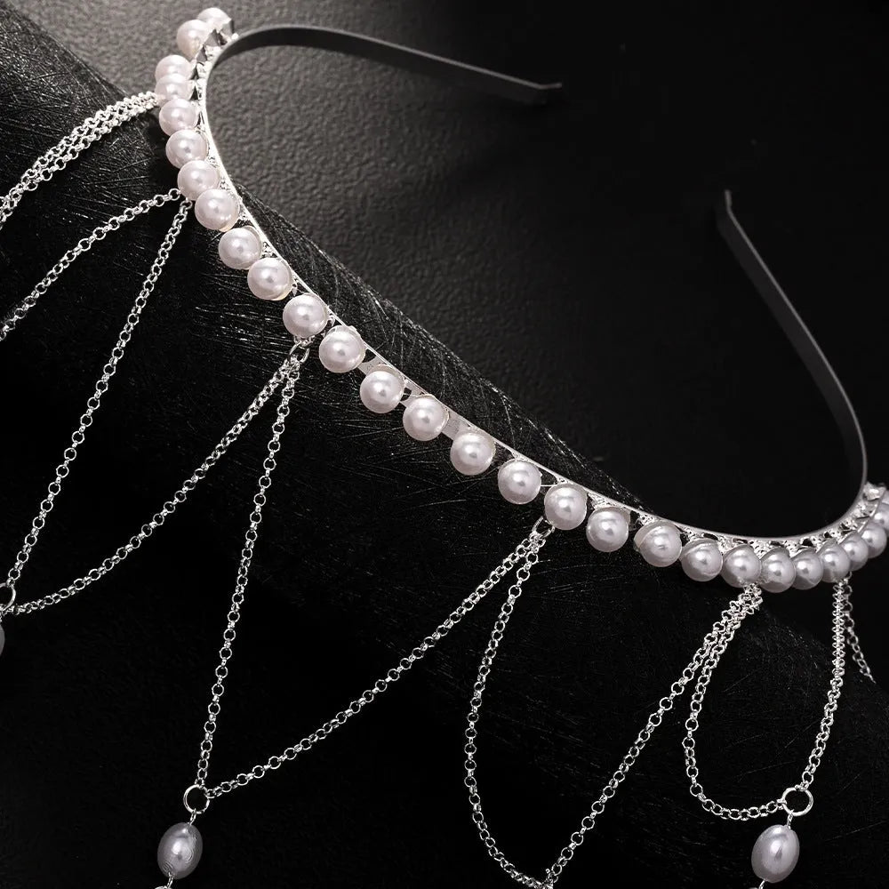 Women's gold and pearl mesh tassel hair chain fashion accessory on white background.