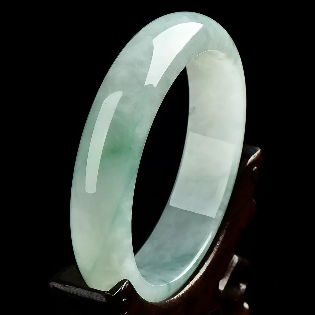 Light green jade bracelet showing natural stone colour and solid band construction