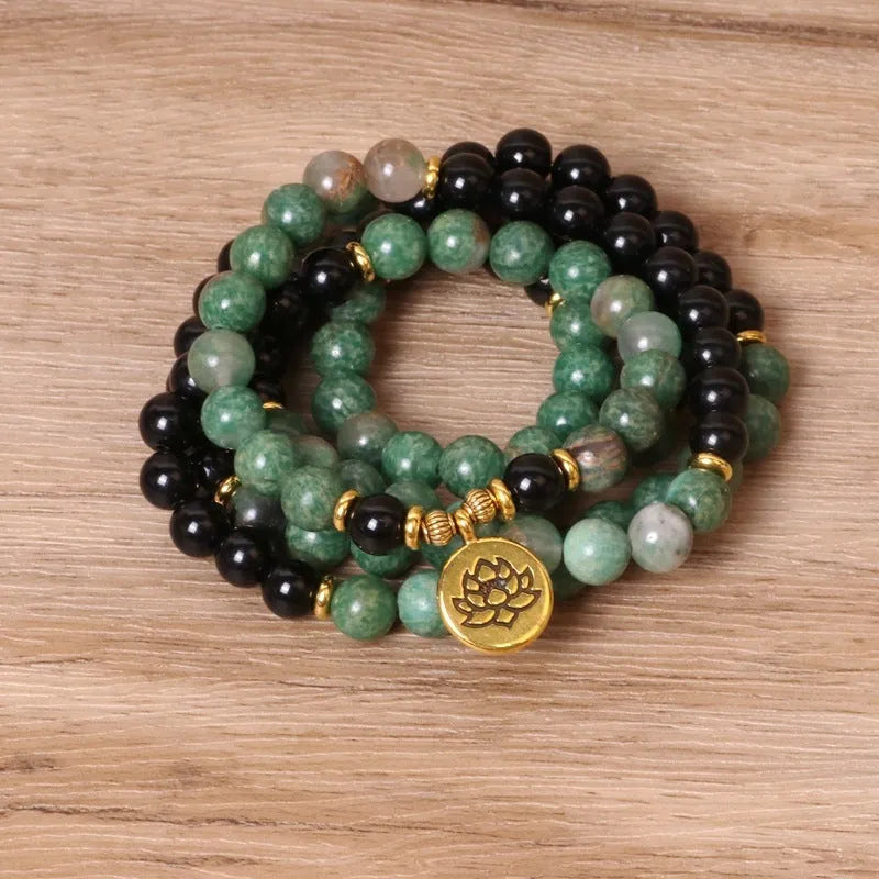 Green and black alloy bead elastic bracelet on wrist showing adjustable stretch design