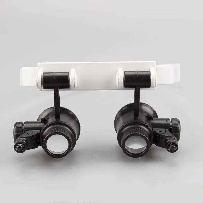White head-mounted magnifying glass with 30mm lenses, shown both unfolded for use and folded for storage