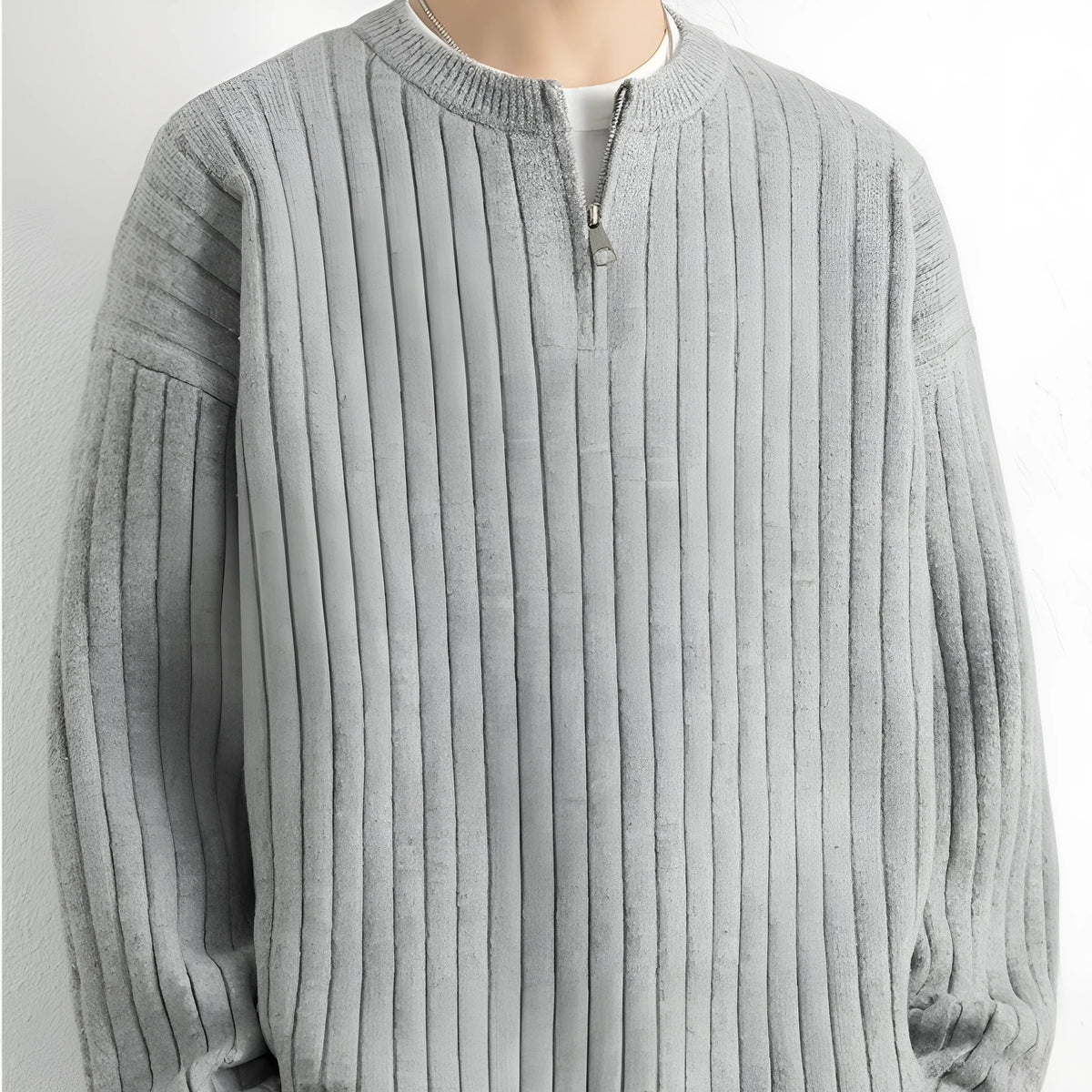 Man wearing a grey half zip loose fit textured knit sweater with long sleeves.