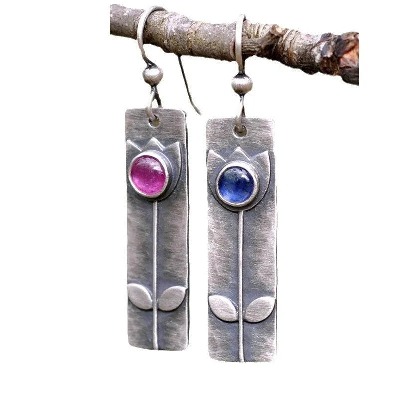 A pair of antique finish red sapphire earrings with a geometric ellipse design in a retro style.