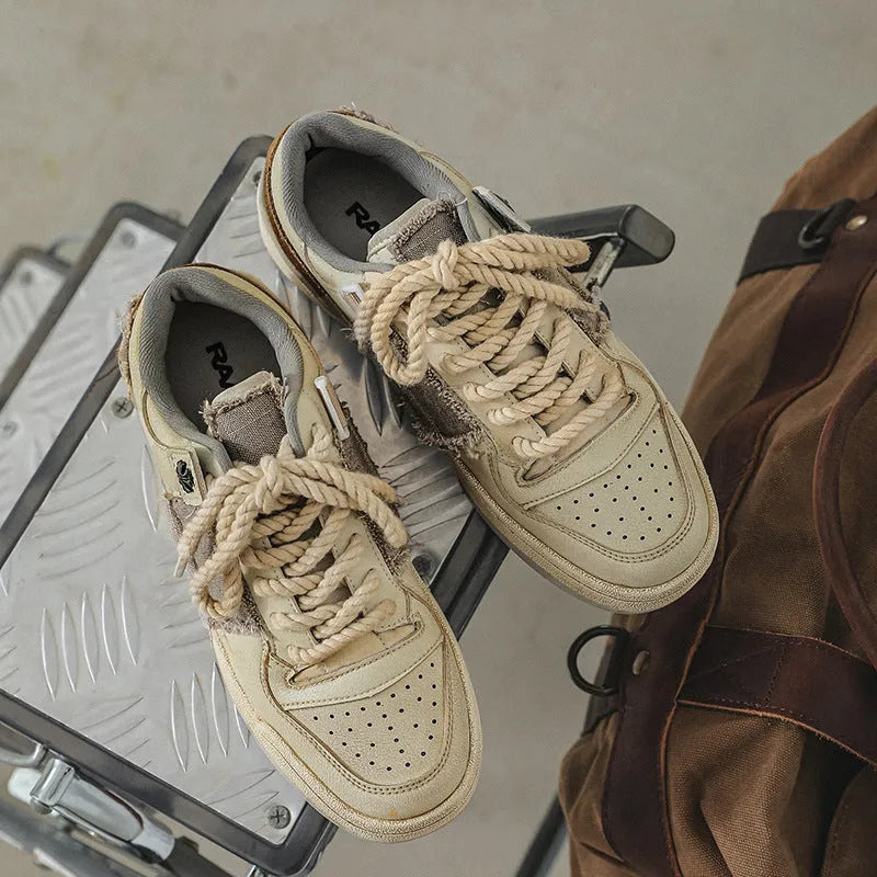 Beige low-top vintage style skateboard shoes with round toe and lace-up front on a rubber sole.