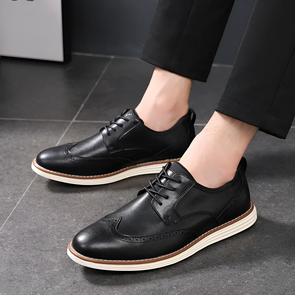 Men's black slip-on business casual shoes with round toe and carved detail on a PU upper.